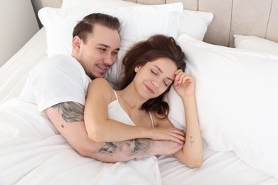 Photo of Happy couple hugging in bed at home