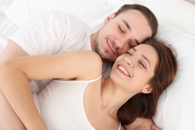 Photo of Happy couple hugging in bed at home