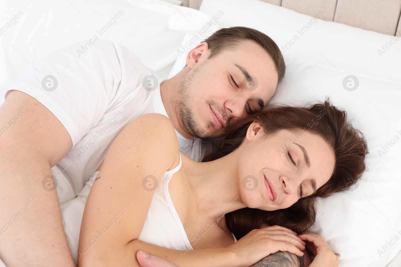 Photo of Cute couple napping on bed at home