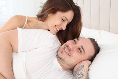 Happy couple spending time together on bed at home