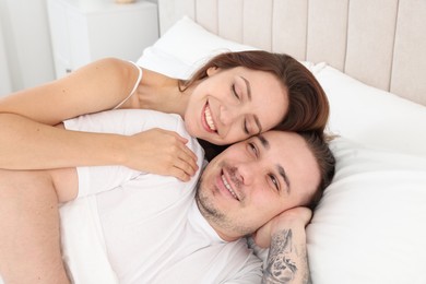 Happy couple spending time together on bed at home