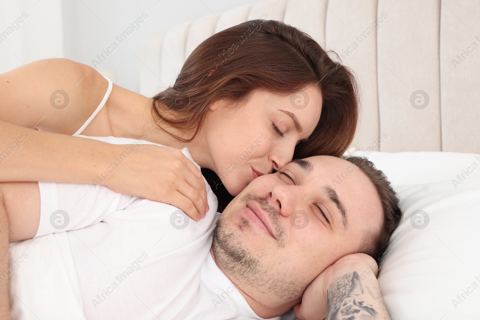 Photo of Happy couple spending time together on bed at home