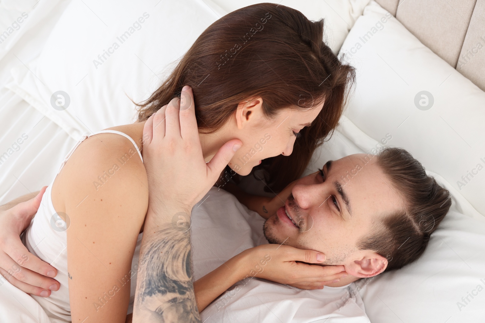 Photo of Happy couple spending time together on bed at home