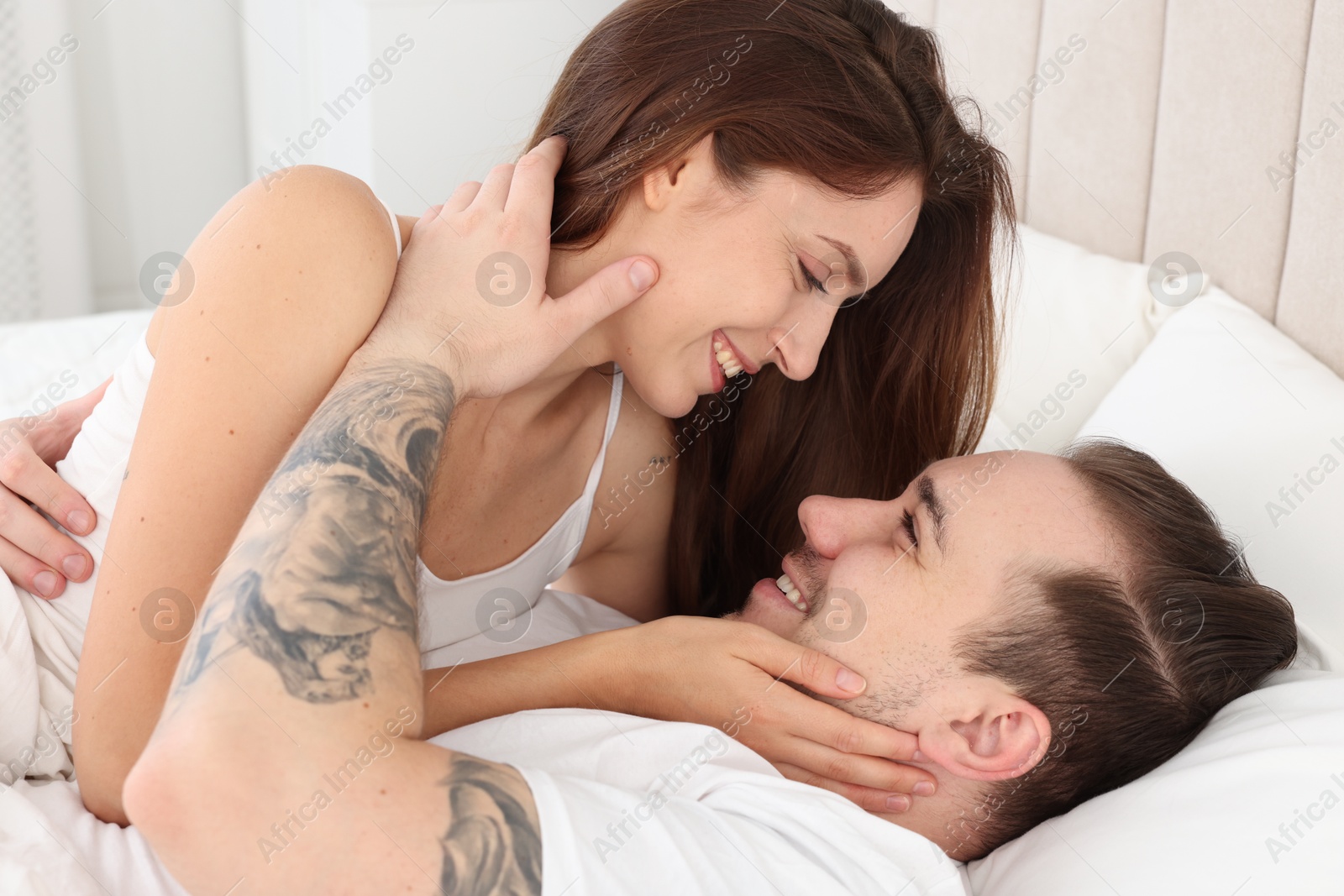 Photo of Happy couple spending time together on bed at home