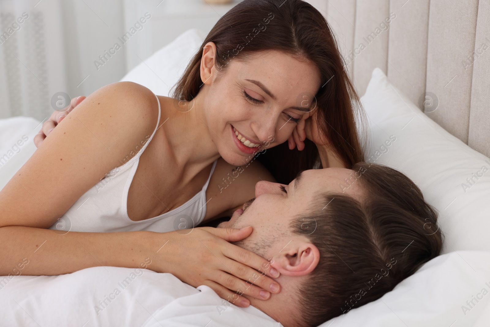 Photo of Happy couple spending time together on bed at home