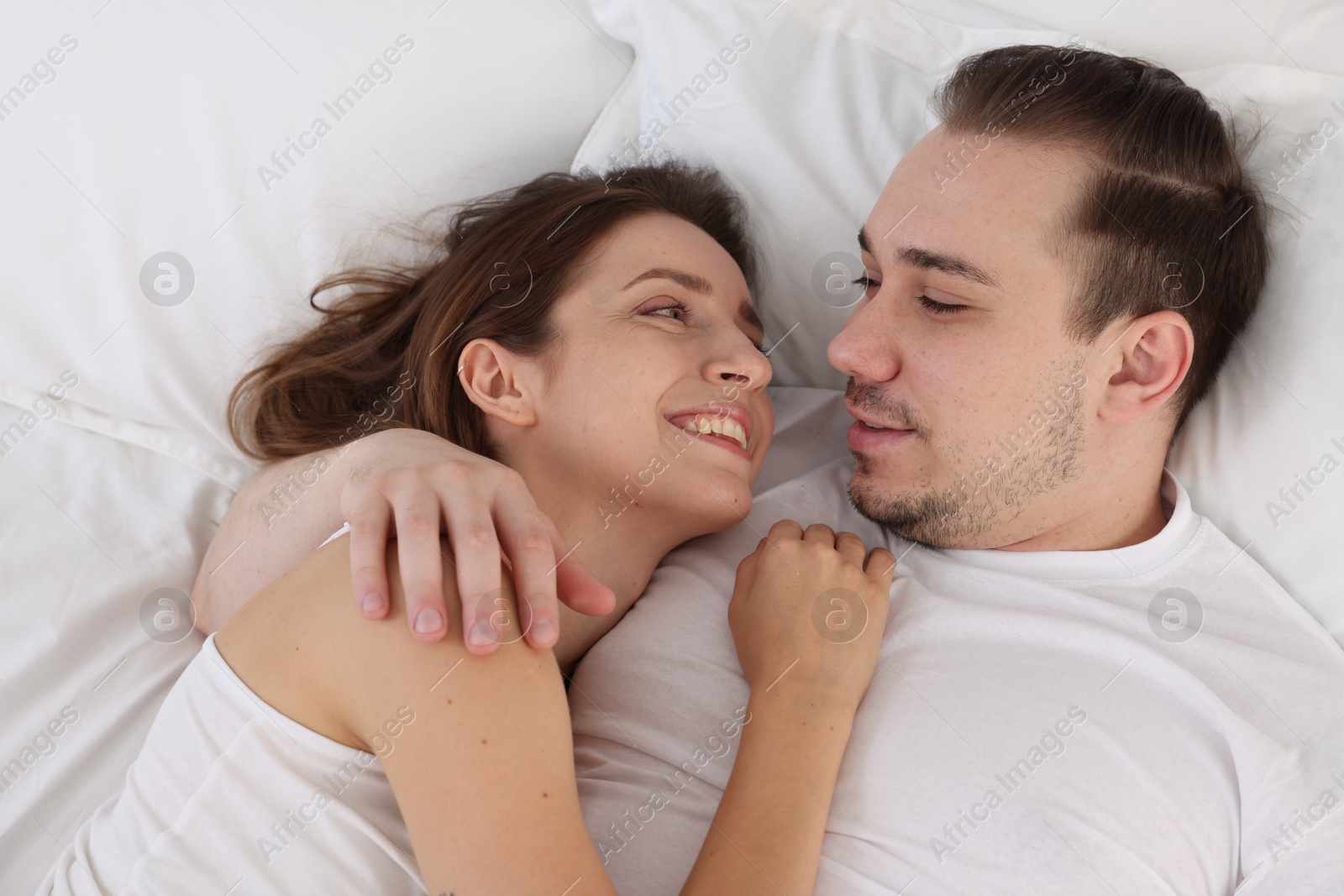 Photo of Happy couple spending time together on bed at home