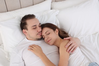 Photo of Cute couple napping in bed at home, top view