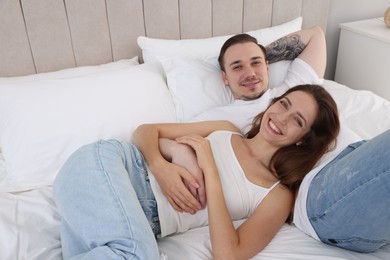 Happy couple spending time together on bed at home