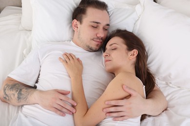 Photo of Cute couple napping on bed at home, top view