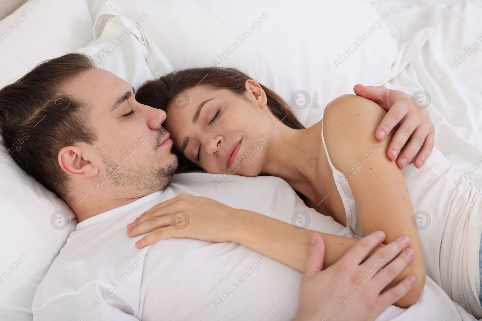 Photo of Cute couple napping on bed at home