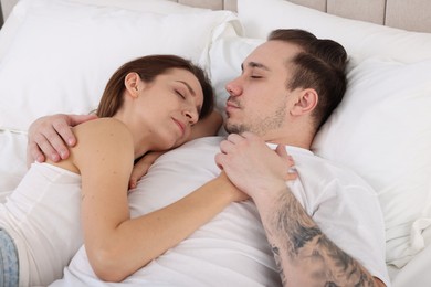 Photo of Cute couple napping on bed at home