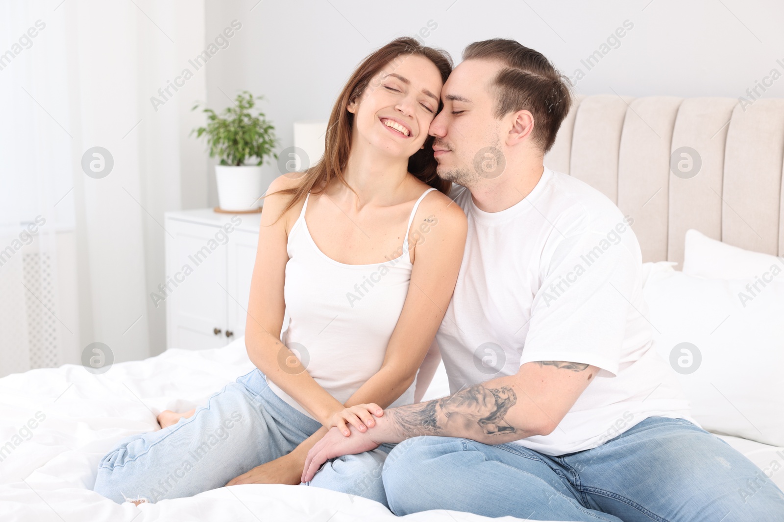 Photo of Happy couple spending time together on bed at home