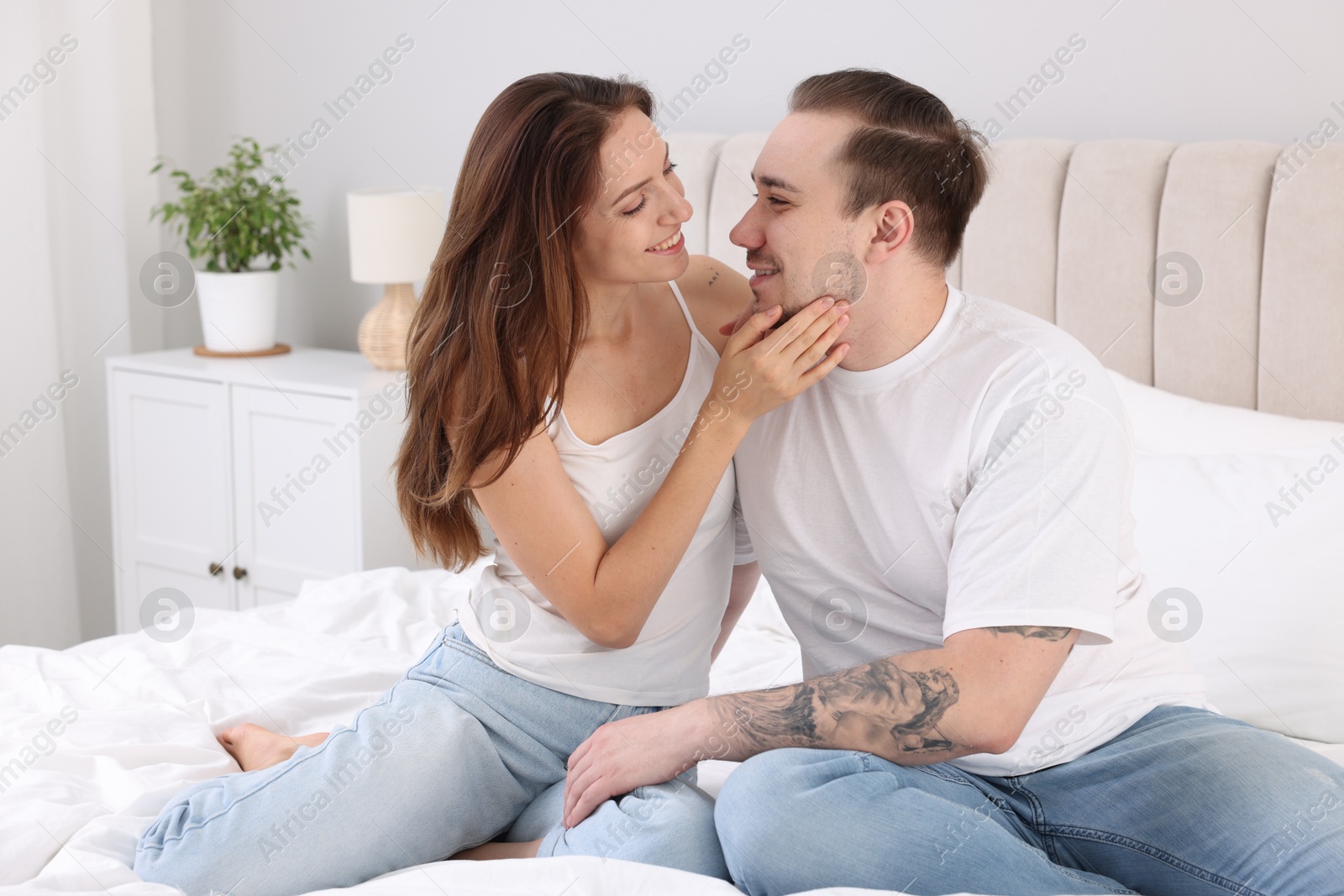 Photo of Happy couple spending time together on bed at home