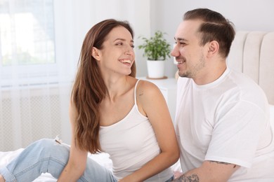 Photo of Happy couple spending time together on bed at home