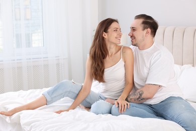 Photo of Happy couple spending time together on bed at home