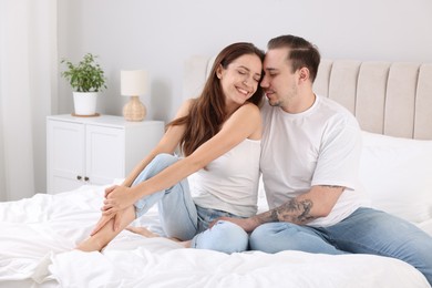 Happy couple spending time together on bed at home