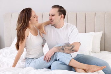 Happy couple spending time together on bed at home