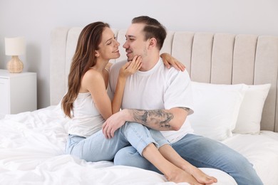 Happy couple spending time together on bed at home