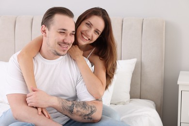 Photo of Happy couple spending time together on bed at home