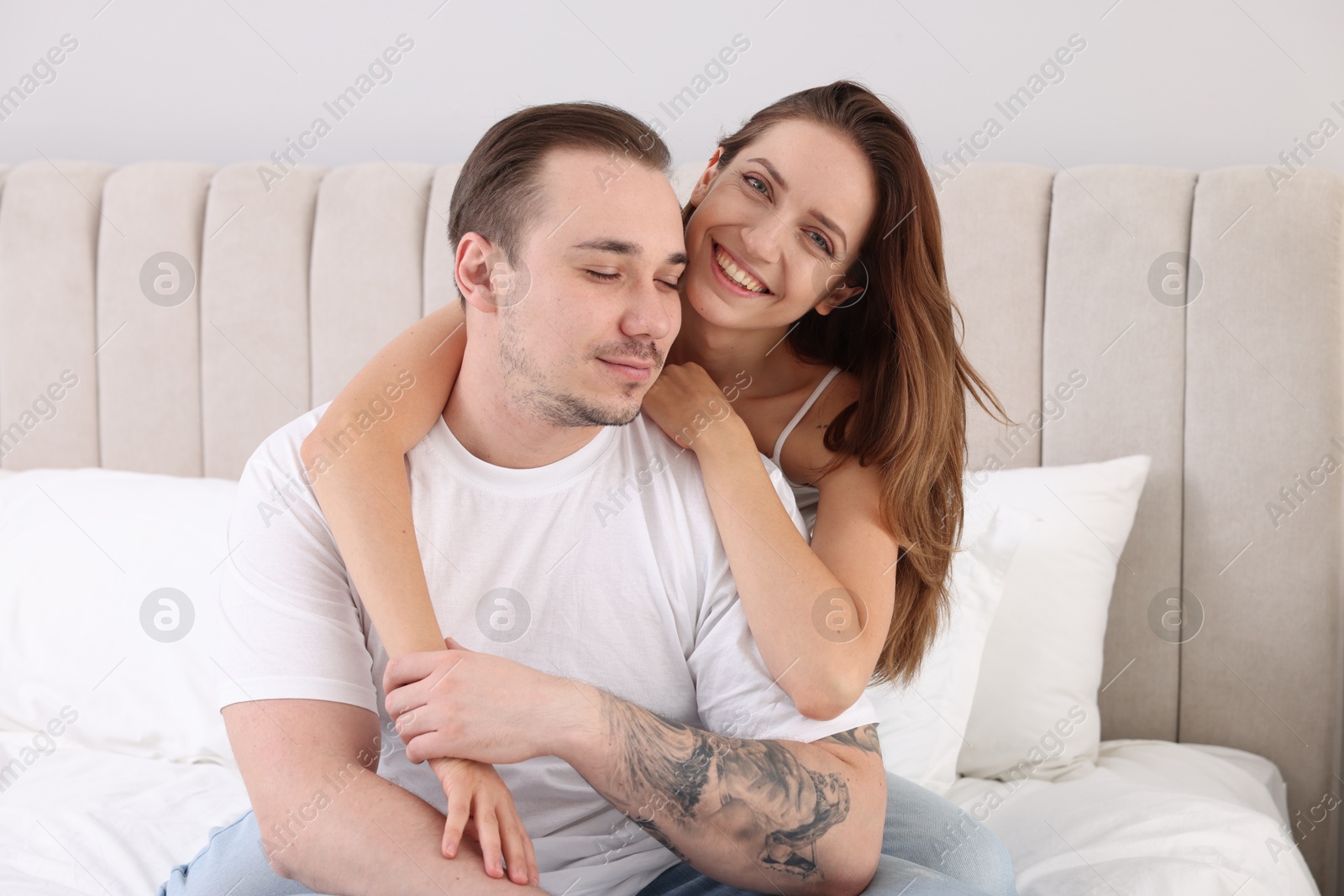 Photo of Happy couple spending time together on bed at home