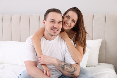 Photo of Happy couple spending time together on bed at home