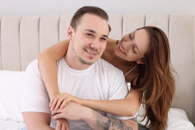 Happy couple spending time together on bed at home