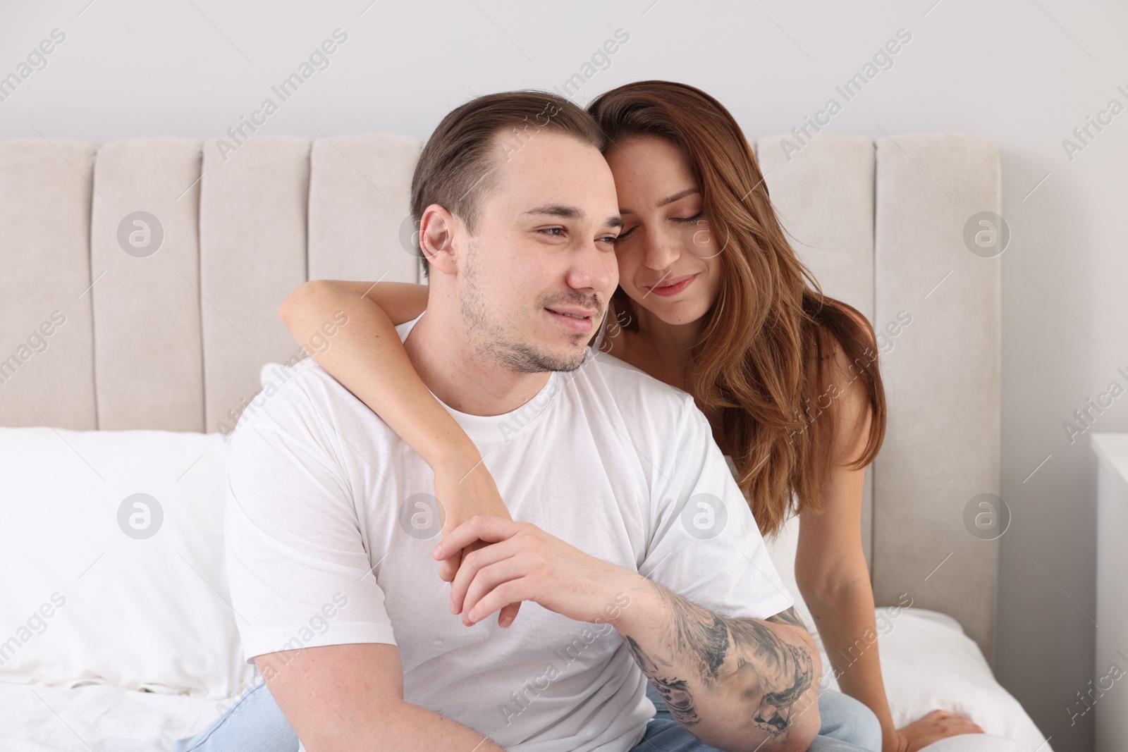 Photo of Cute couple spending time together on bed at home