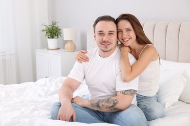 Photo of Happy couple spending time together on bed at home. Space for text