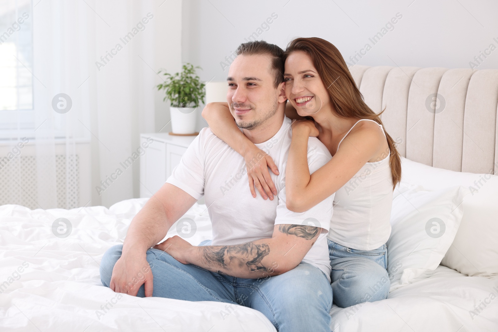 Photo of Happy couple spending time together on bed at home