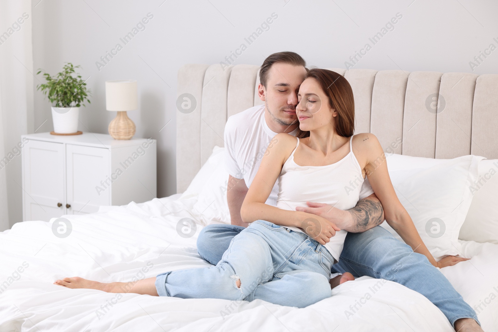 Photo of Cute couple spending time together on bed at home