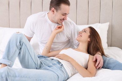 Happy couple spending time together on bed at home