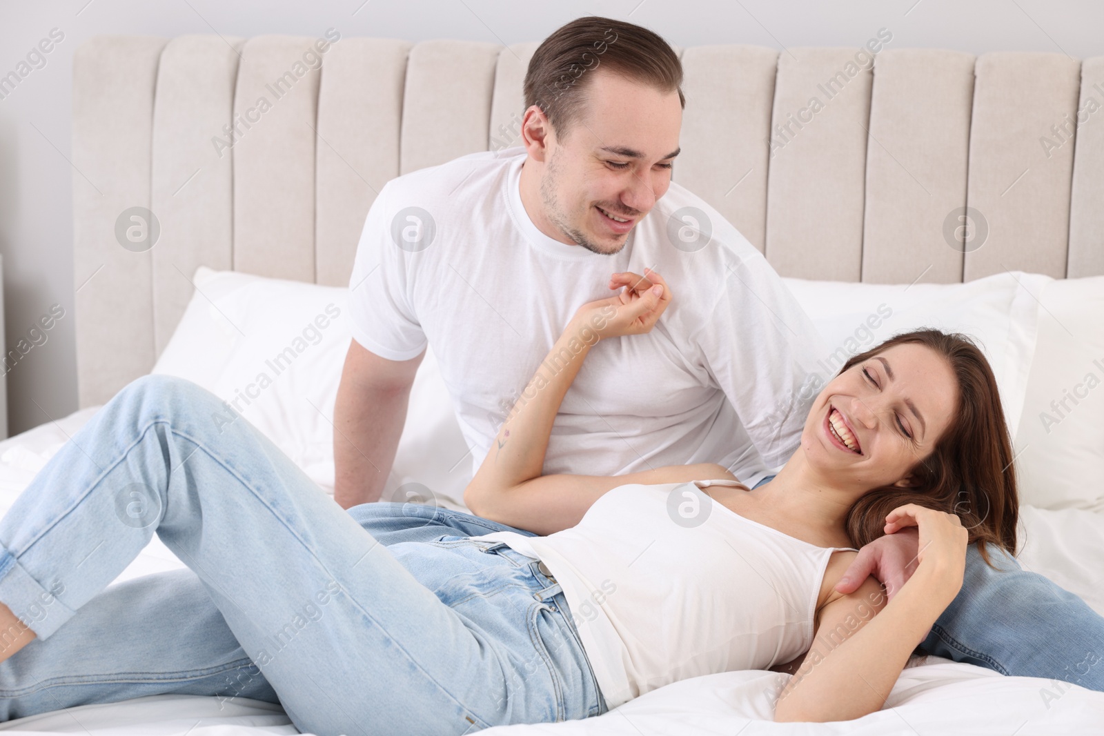 Photo of Happy couple spending time together on bed at home