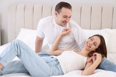 Photo of Happy couple spending time together on bed at home