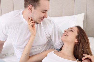 Happy couple spending time together on bed at home