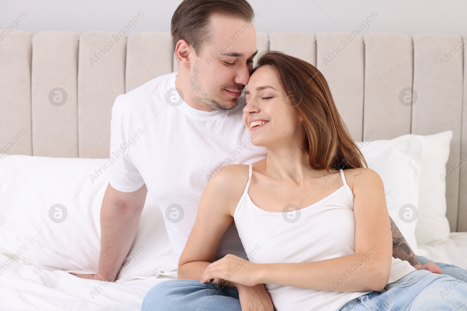 Photo of Happy couple spending time together on bed at home