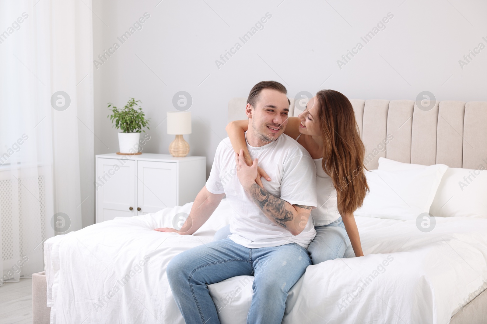 Photo of Happy couple spending time together on bed at home