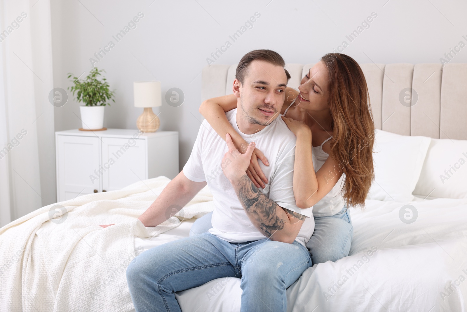 Photo of Happy couple spending time together on bed at home