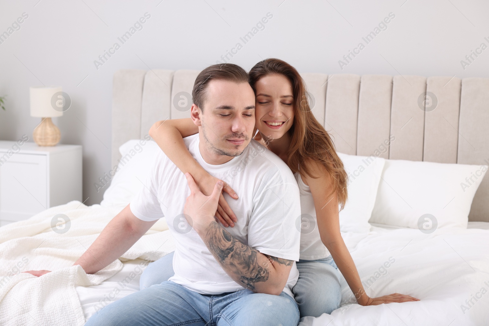 Photo of Happy couple spending time together on bed at home