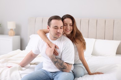 Happy couple spending time together on bed at home