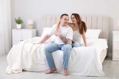 Happy couple spending time together on bed at home