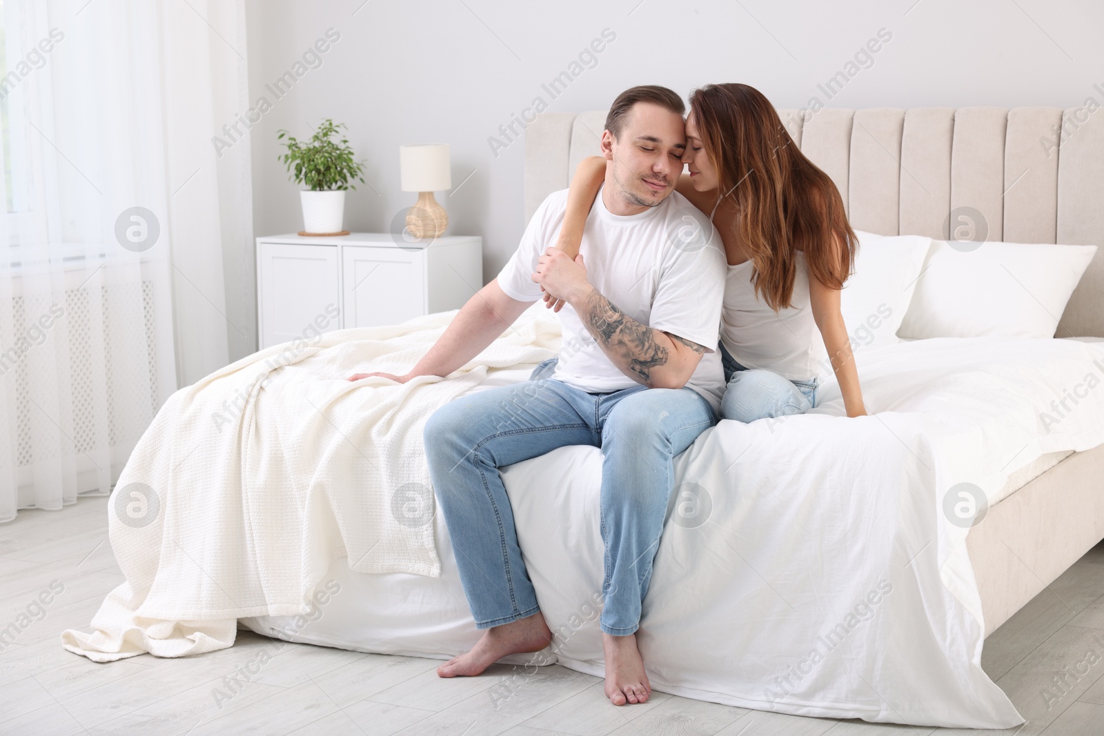 Photo of Cute couple spending time together on bed at home