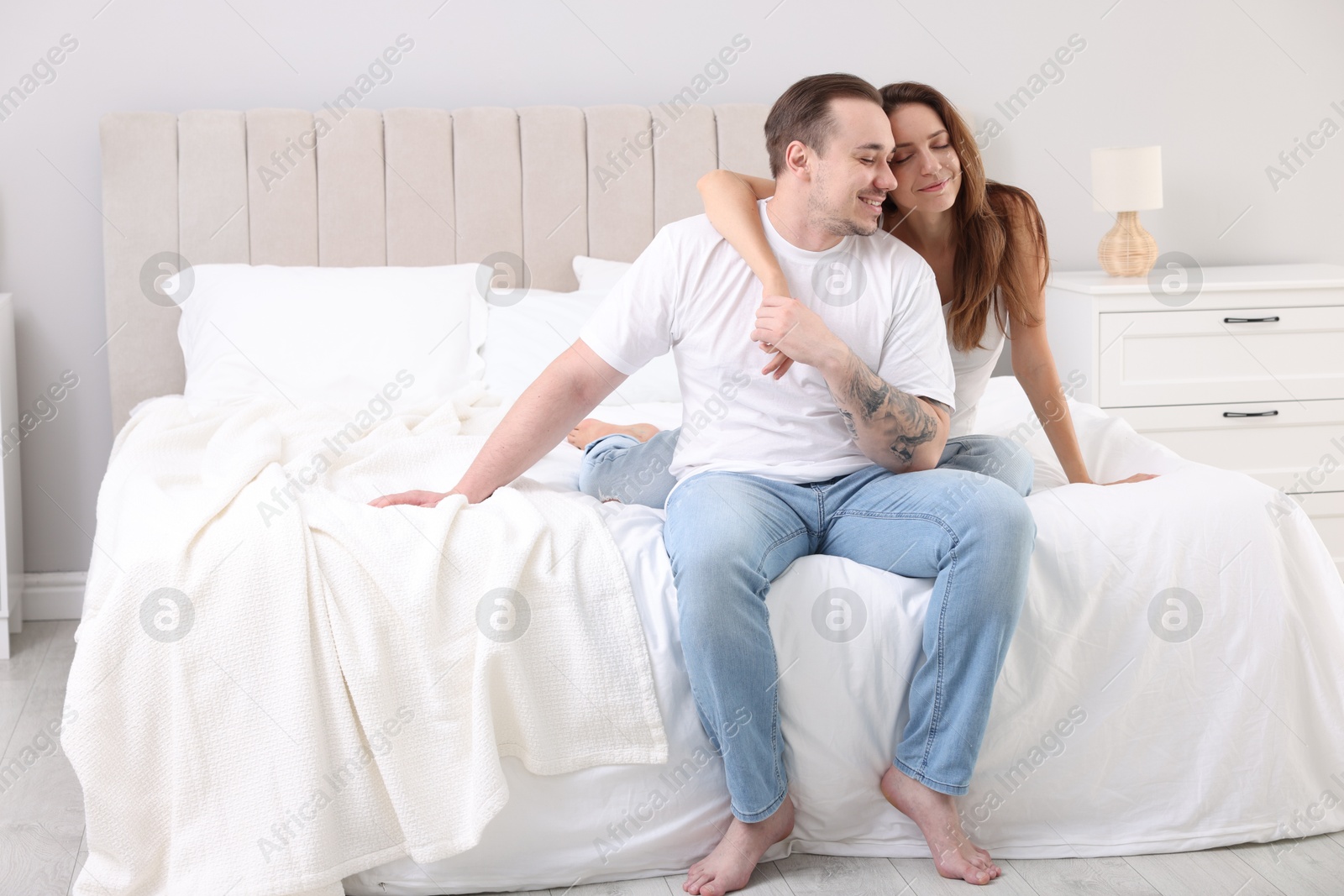 Photo of Happy couple spending time together on bed at home