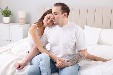 Cute couple spending time together on bed at home