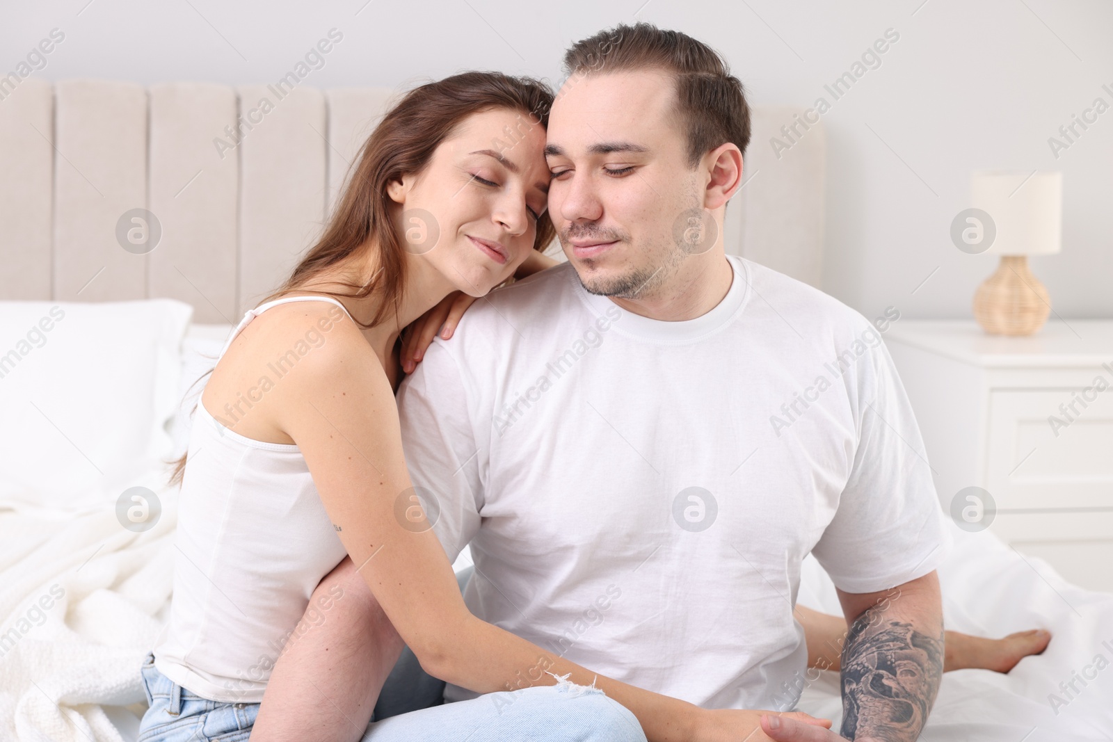 Photo of Cute couple spending time together on bed at home