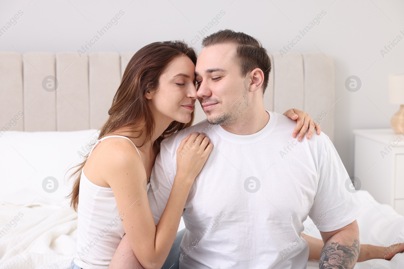 Photo of Cute couple spending time together on bed at home