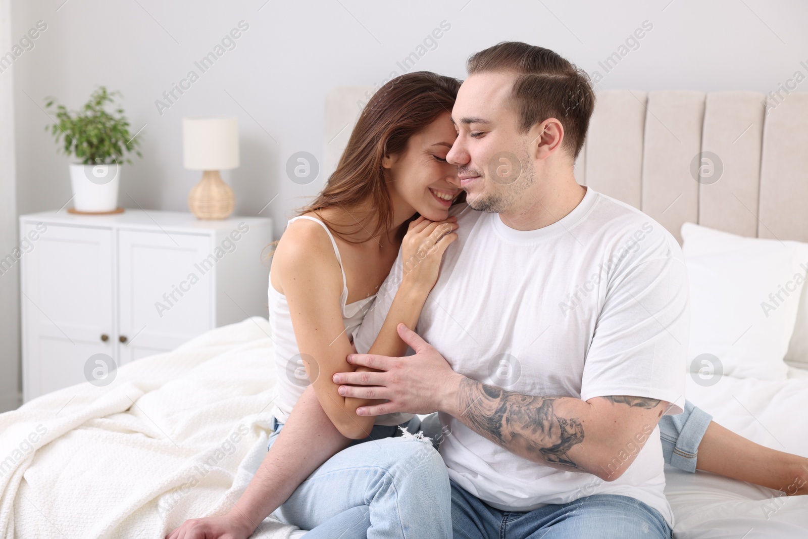 Photo of Happy couple spending time together on bed at home