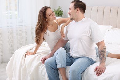 Happy couple spending time together on bed at home