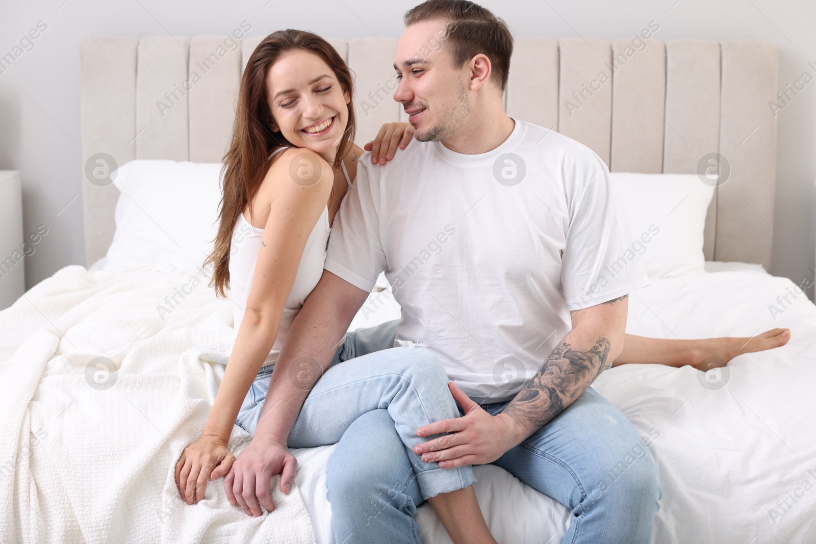 Photo of Happy couple spending time together on bed at home