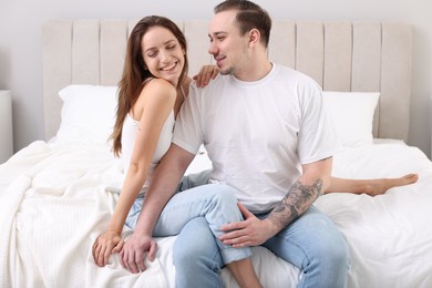 Happy couple spending time together on bed at home