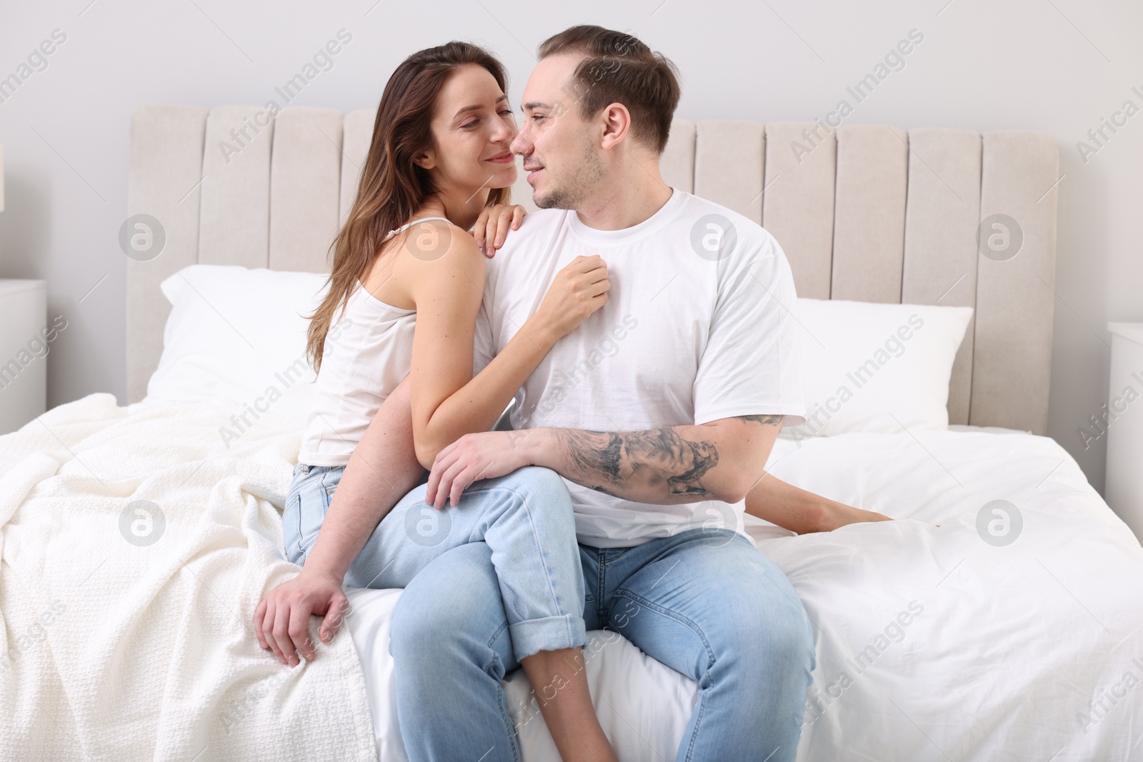 Photo of Cute couple spending time together on bed at home